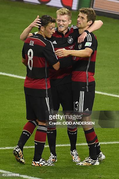 Germany's forward Andre Schuerrle celebrates with team mates after scoring during the semi-final football match between Brazil and Germany at The...