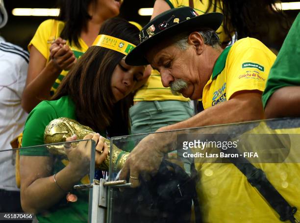 Brazil fans react after the 1-7 defeat in the 2014 FIFA World Cup Brazil Semi Final match between Brazil and Germany at Estadio Mineirao on July 8,...