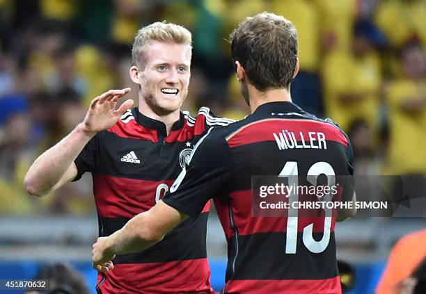 Germany's forward Andre Schuerrle is congratulated by Germany's forward Thomas Mueller after scoring during the semi-final football match between...