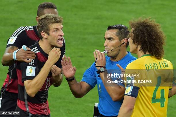Mexican referee Marco Rodriguez stands in between Brazil's defender David Luiz and Germany's forward Thomas Mueller arguing during the semi-final...