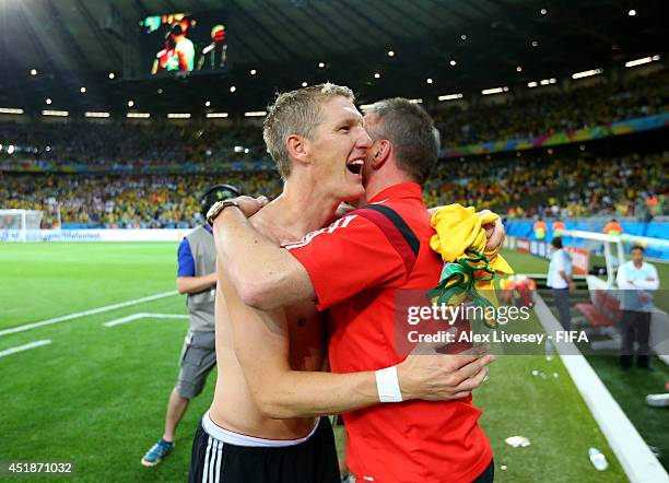 Bastian Schweinsteiger of Germany celebrates the 7-1 win with kit man Thomas Mai after the 2014 FIFA World Cup Brazil Semi Final match between Brazil...