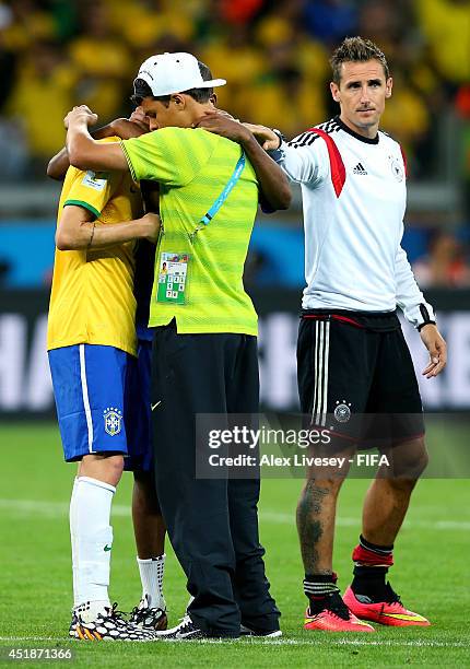 Miroslav Klose of Germany consoles Thiago Silva and Oscar of Brazil after the 2014 FIFA World Cup Brazil Semi Final match between Brazil and Germany...