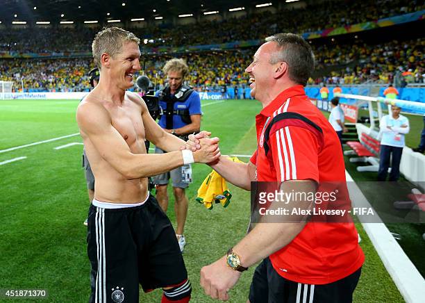 Bastian Schweinsteiger of Germany celebrates the 7-1 win with kit man Thomas Mai after the 2014 FIFA World Cup Brazil Semi Final match between Brazil...