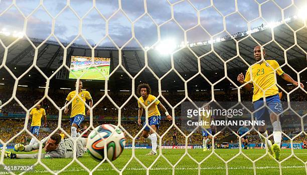 Brazil's goalkeeper Julio Cesar concedes a goal during the semi-final football match between Brazil and Germany at The Mineirao Stadium in Belo...