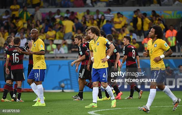 Germany's players celebrate and Brazil's defender David Luiz and Brazil's defender Maicon react after unseen forward Miroslav Klose scored during the...