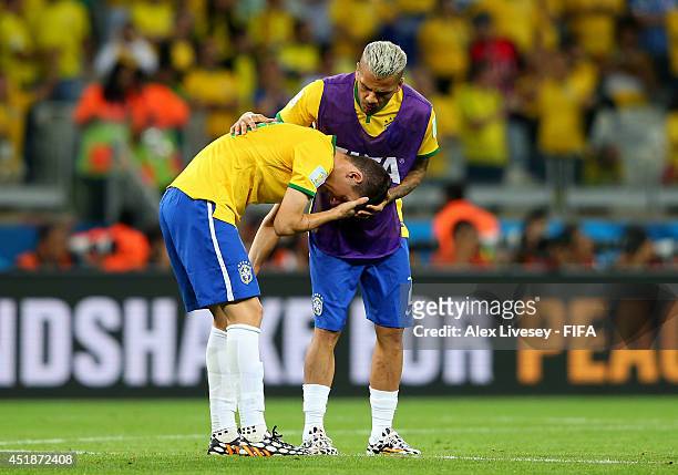 Oscar is consoled by his teammate Dani Alves of Brazil after 1-7 defeat in the 2014 FIFA World Cup Brazil Semi Final match between Brazil and Germany...