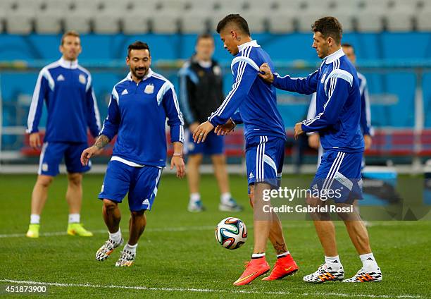 Marcos Rojo controls the ball as Ezequiel Lavezzi smiles during a training session at Arena Corinthians on July 08, 2014 in Sao Paulo, Brazil....