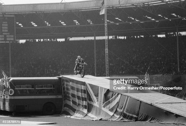 American motorcycle stunt rider Evel Knievel touches down after jumping his Harley-Davidson XR-750 over 13 AEC Merlin buses at Wembley Stadium,...