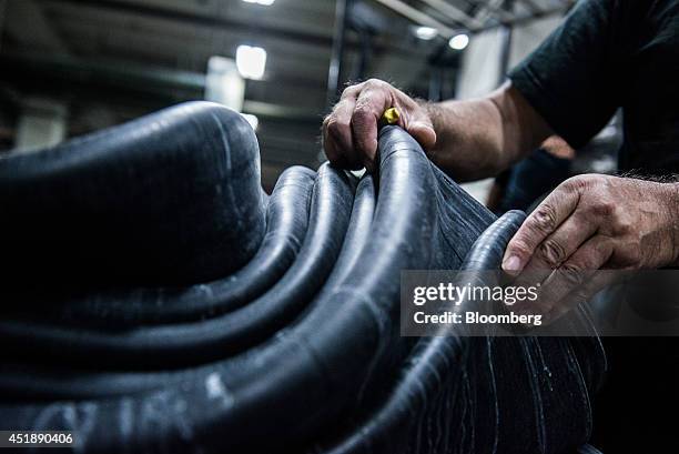 Worker lays out lengths of rubber strips ahead of moulding into automobile tires at the Continental AG plant in Timisoara, Romania, on Wednesday,...
