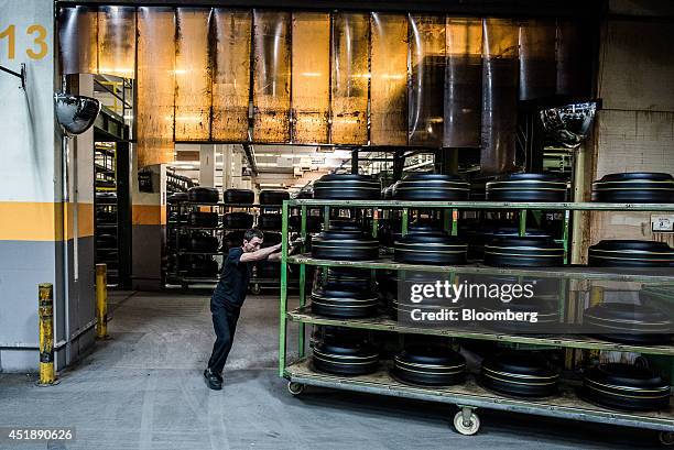 Worker uses a trolley to move rubber tire moulds to tread cutting machines at the Continental AG automobile tire manufacturing plant in Timisoara,...