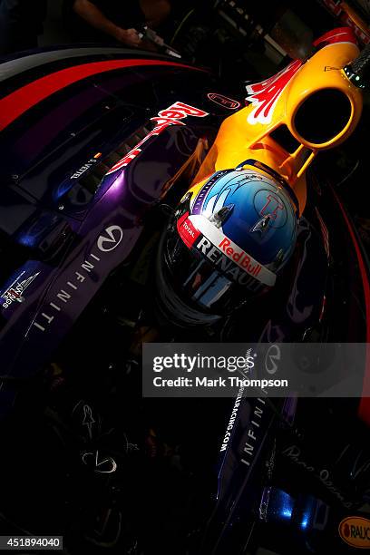 Sebastian Vettel of Germany and Infiniti Red Bull Racing sits in his car in the garage during day two of testing at Silverstone Circuit on July 9,...