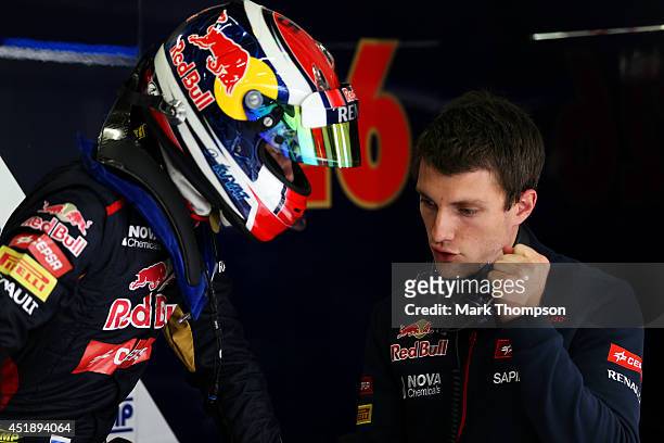 Daniil Kvyat of Russia and Scuderia Toro Rosso speaks with a member of his team in the garage during day two of testing at Silverstone Circuit on...