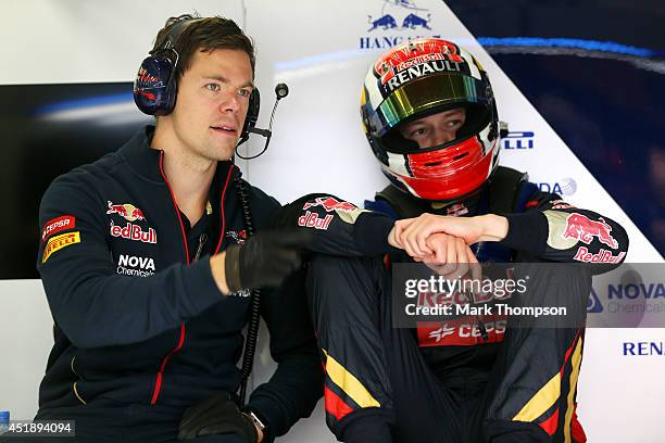 Daniil Kvyat of Russia and Scuderia Toro Rosso speaks with a member of his team in the garage during day two of testing at Silverstone Circuit on...