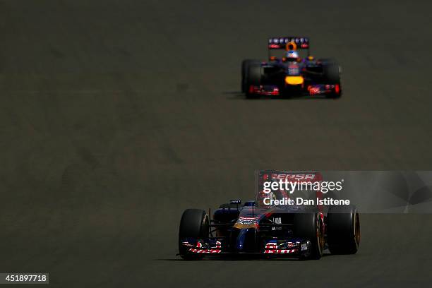 Daniil Kvyat of Russia and Scuderia Toro Rosso drives ahead of Sebastian Vettel of Germany and Infiniti Red Bull Racing during day two of testing at...