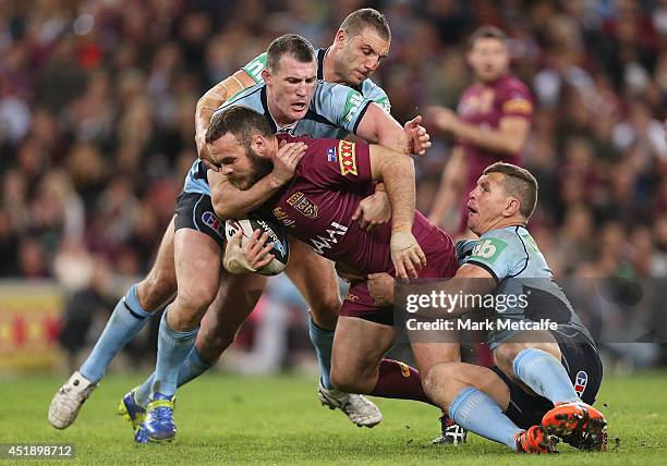 Nate Myles of the Maroons is tackled during game three of the State of Origin series between the Queensland Maroons and the New South Wales Blues at...