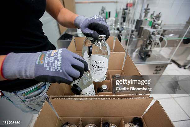 An employee packages bottles of Our/Berlin vodka, a brand of Pernod Ricard SA, ahead of shipping at the Pauline Hoch & Jon D. Sanders distillery in...