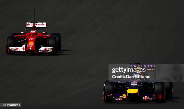 Sebastian Vettel of Germany and Infiniti Red Bull Racing leads Jules Bianchi of France driving a Ferrari during day two of testing at Silverstone...