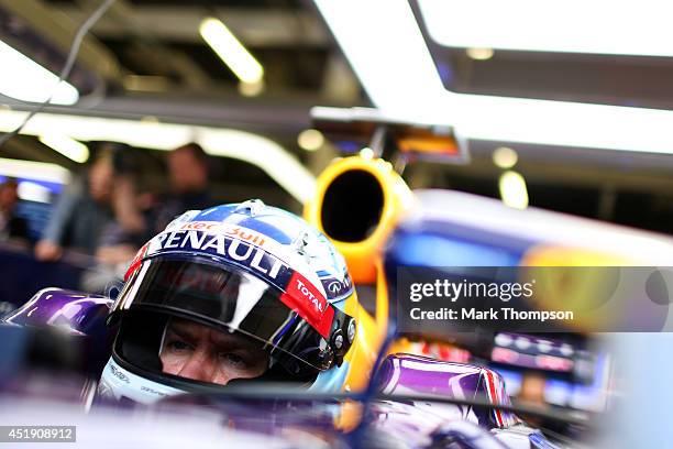 Sebastian Vettel of Germany and Infiniti Red Bull Racing sits in his car in the garage during day two of testing at Silverstone Circuit on July 9,...