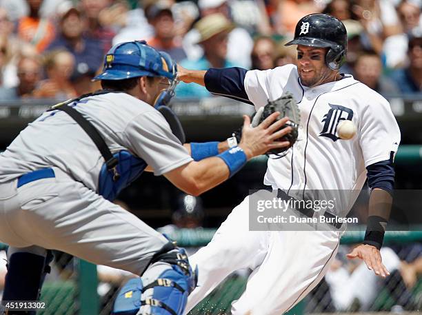 Martinez of the Detroit Tigers beats the throw to catcher A.J. Ellis of the Los Angeles Dodgers to score from second base on a single by Nick...