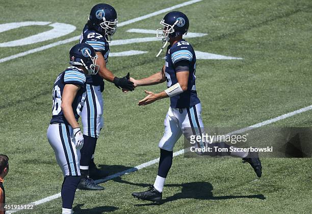 Ricky Ray of the Toronto Argonauts is greeted by Mike Bradwell and Shane Horton as he is introduced before the start of CFL game action against the...
