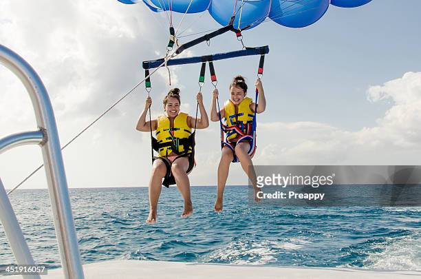 teenage girls parasailing - grand cayman stockfoto's en -beelden