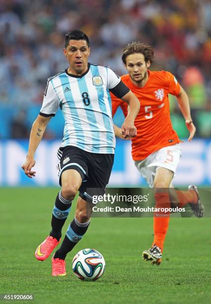 Enzo Perez of Argentina controls the ball against Daley Blind of the Netherlands during the 2014 FIFA World Cup Brazil Semi Final match between the...