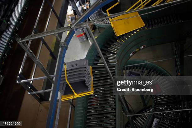 Buckets move down a conveyor belt after fulfilling online orders for luxury fashion items and home goods are fulfilled at the Gilt Groupe Inc....