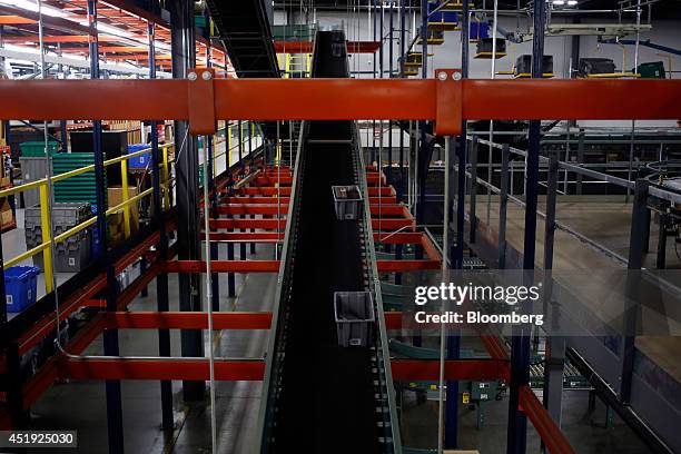 Buckets move down a conveyor belt as online orders for luxury fashion items and home goods are fulfilled at the Gilt Groupe Inc. Distribution center...