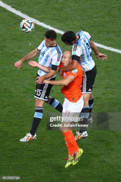 Arjen Robben of the Netherlands goes up for a header against Martin Demichelis and Ezequiel Garay of Argentina during the 2014 FIFA World Cup Brazil...