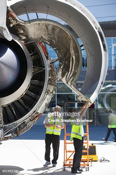 Crews work on the Rolls Royce engine of an Air New Zealand Boeing 787-9 Dreamliner, July 9, 2014 in Everett, Washington. The 787-9 Dreamliner was the...