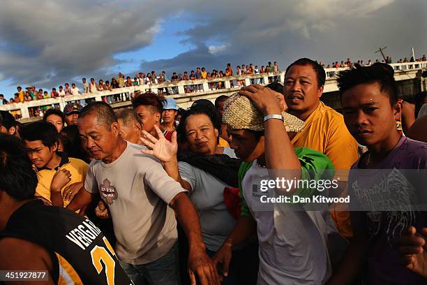 People scramble for supplies after an air drop by the Philippine Air Force at first light in a remote village on November 15, 2013 in Leyte,...