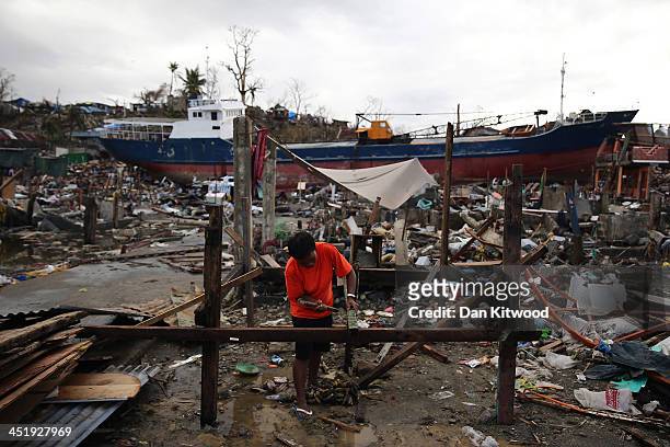 Man begins to rebuild his home on the shoreline where several tankers ran aground in Tacloban on November 17, 2013 in Leyte, Philippines. Typhoon...