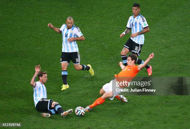 Daryl Janmaat of the Netherlands challenges Lucas Biglia of Argentina during the 2014 FIFA World Cup Brazil Semi Final match between the Netherlands...