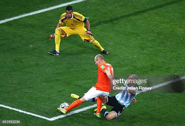 Javier Mascherano of Argentina tackles Arjen Robben of the Netherlands as he attempts a shot against goalkeeper Sergio Romero during the 2014 FIFA...