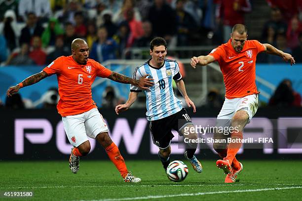 Lionel Messi of Argentina competes for the ball against Nigel de Jong and Ron Vlaar of the Netherlands during the 2014 FIFA World Cup Brazil Semi...