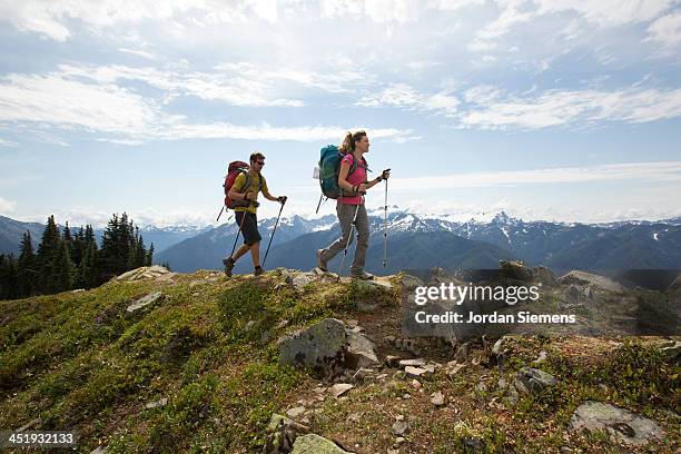 man and woman hiking outdoors - olympic nationalpark stock-fotos und bilder