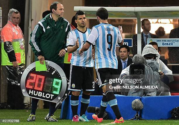 Argentina's forward Sergio Aguero shakes hands with Argentina's forward Gonzalo Higuain as he comes onto the pitch to replace him during the...