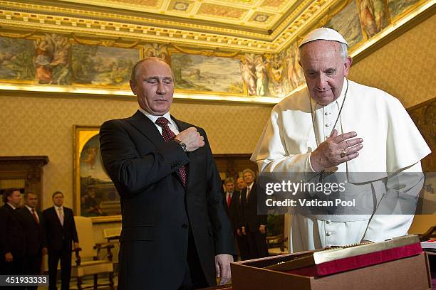 Pope Francis exchanges gifts with Russian President Vladimir Putin during a private audience at his library on November 25, 2013 in Vatican City,...