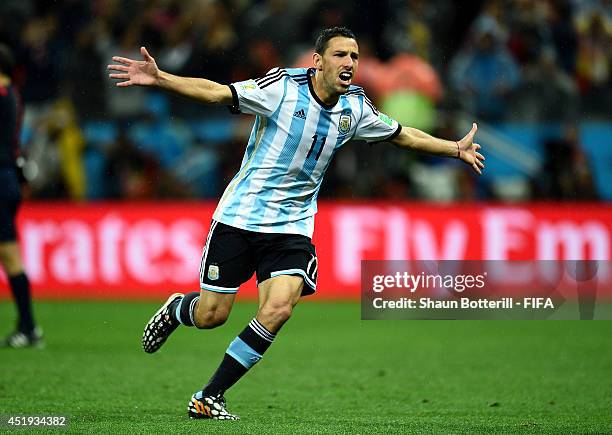 Maxi Rodriguez of Argentina celebrates after scoring a penalty in the penalty shootout to win the 2014 FIFA World Cup Brazil Semi Final match between...