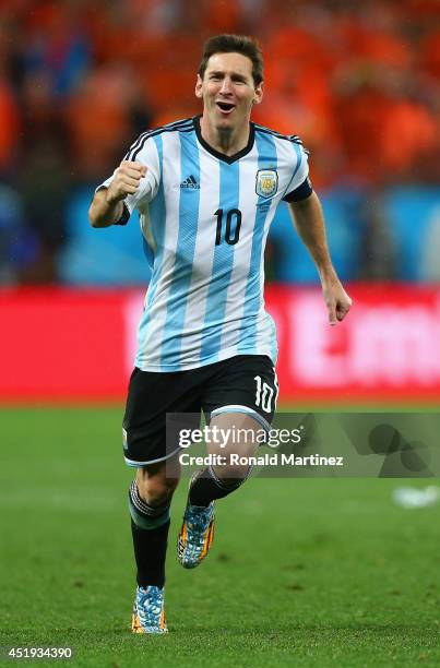 Lionel Messi of Argentina celebrates defeating the Netherlands in a shootout during the 2014 FIFA World Cup Brazil Semi Final match between the...