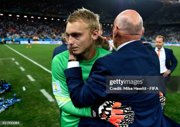 Jasper Cillessen of the Netherlands is consoled by a team staff while walking off the pitch after the defeat in a penalty shootout in the 2014 FIFA...