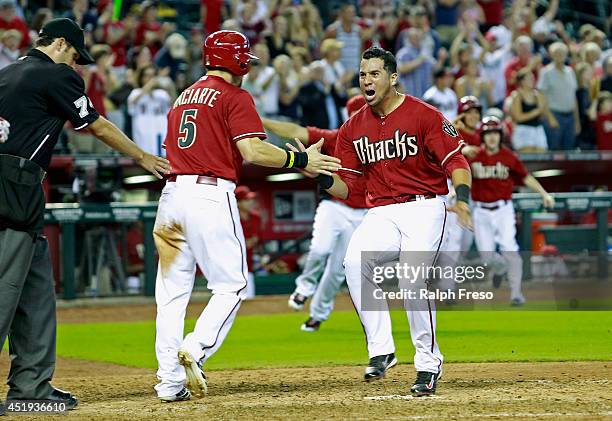 David Peralta and Ender Inciarte of the Arizona Diamondbacks celebrate as they score on teammate Paul Goldschmidt's game winning walk-off double...