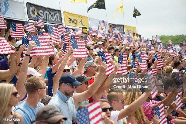 Fans hold up American flags during the National Anthem at the AVP Milwaukee Open on July 6, 2014 at Bradford Beach in St in Milwaukee, Wisconsin.