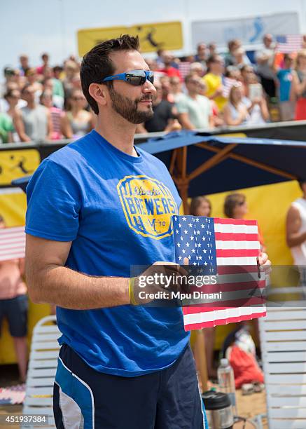 Fan holds an American flag during the National Anthem at the AVP Milwaukee Open on July 6, 2014 at Bradford Beach in St in Milwaukee, Wisconsin.