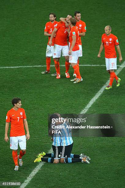 Javier Mascherano of Argentina celebrates with his team mate Ezequiel Garay defeating the Netherlands in a shootout whilst Daryl Janmaat of...