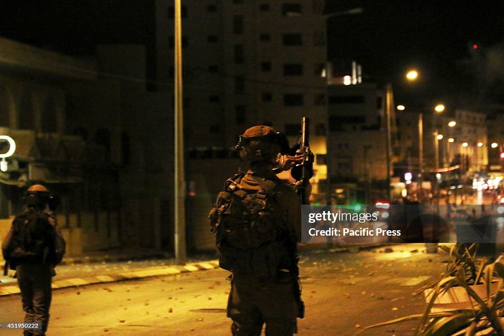 An Israeli soldier adjusts his tear gas gun, making sure he...