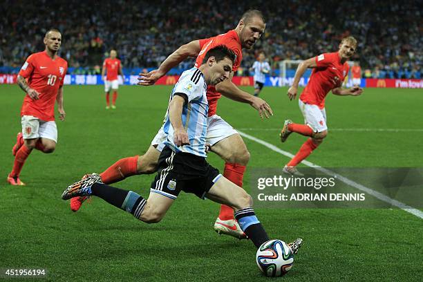 Argentina's forward and captain Lionel Messi controls the ball next to Netherlands' defender Ron Vlaar during extra time of the semi-final football...