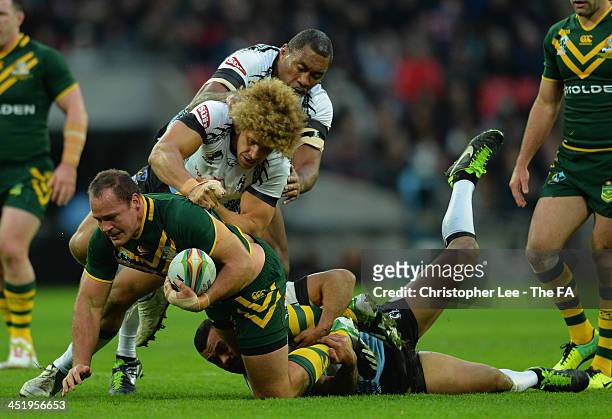 Matthew Scott of Australia is tackled by Petero Civoniceva, Eloni Vunakece and Jayson Bukuya of Fiji during the Rugby League World Cup Semi Final...
