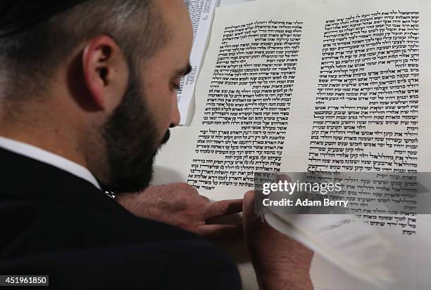 Rabbi and Torah Scribe Reuven Yaacobov copies by hand a section of the Torah with a quill pen on July 10, 2014 in the Jewish Museum in Berlin,...