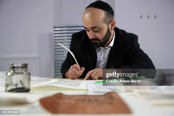 Rabbi and Torah Scribe Reuven Yaacobov copies by hand a section of the Torah with a quill pen on July 10, 2014 in the Jewish Museum in Berlin,...